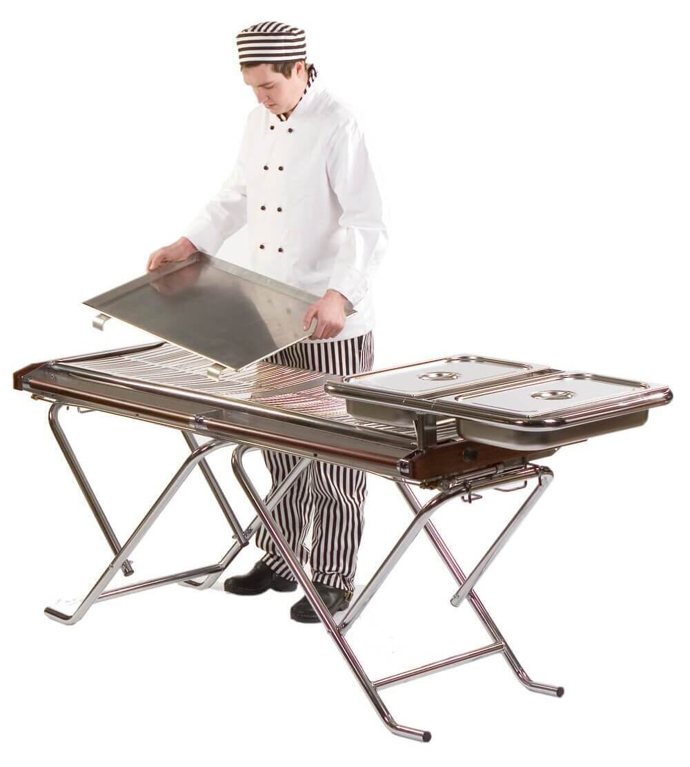 A chef fitting a tray to a Cinders TG160 Commercial Gas BBQ