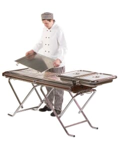 A chef fitting a tray to a Cinders TG160 Commercial Gas BBQ