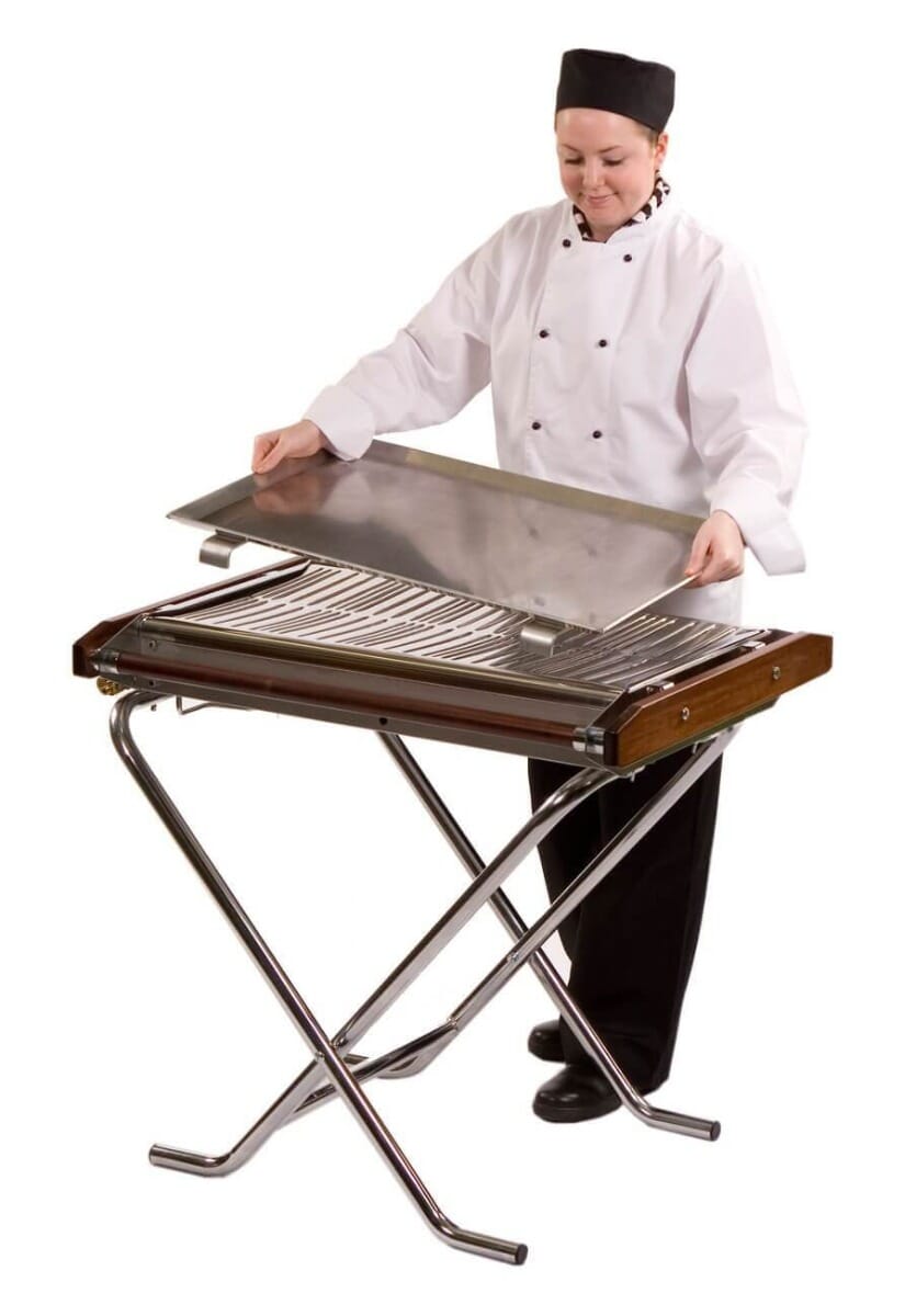 A lady chef adding a tray to the top of the Cinders Classic SG80 Gas BBQ